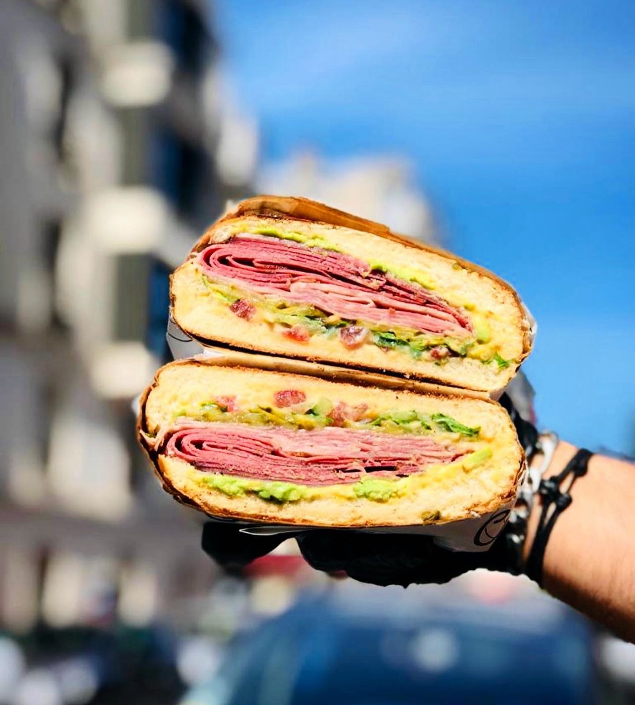 Chlew sandwich held against Dubai sky